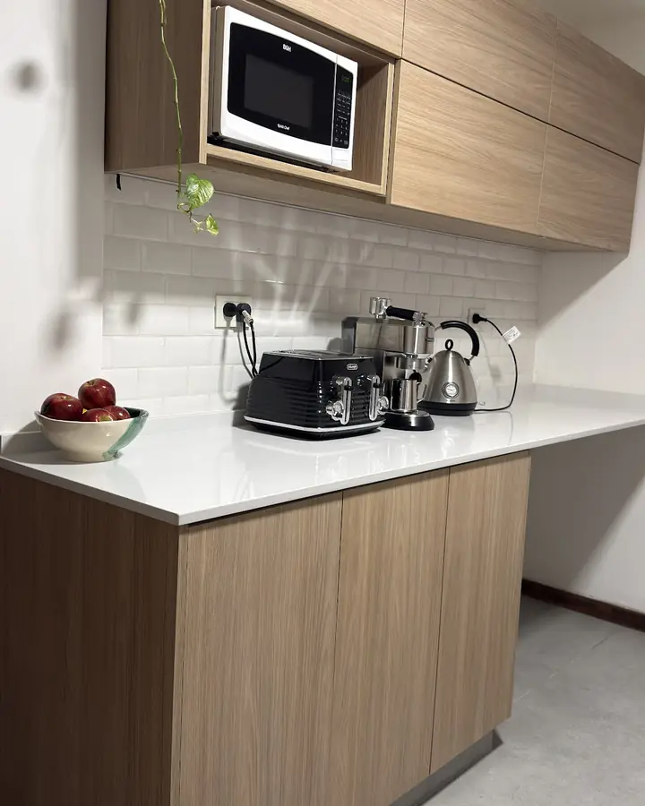 Bajo mesada y alacenas en tono madera con microondas empotrado
