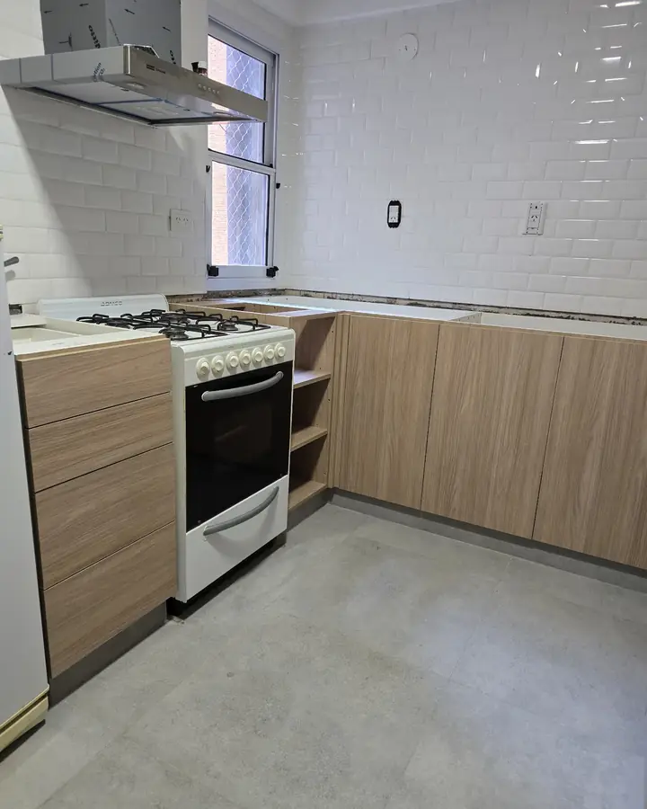 Cocina en L en tono madera con horno