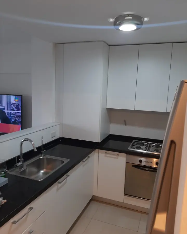 Cocina blanca en L con mesada oscura